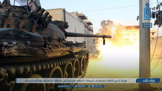 This photo provided  by the al-Qaida-affiliated Ibaa News Network, shows a tank of the al-Qaida-linked coalition known as Hay'at Tahrir al-Sham, Hay'at Tahrir al-Sham, Arabic for Levant Liberation Committee, firing at Syrian troops and pro-government gunmen in rural Aleppo, Syria. 