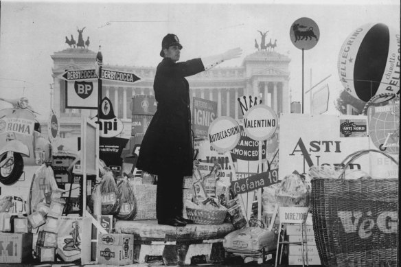 A traffic policeman on duty in the Piazza Venezia, Rome, in 1962, surrounded by New Year gifts from grateful motorists and pedestrians.
