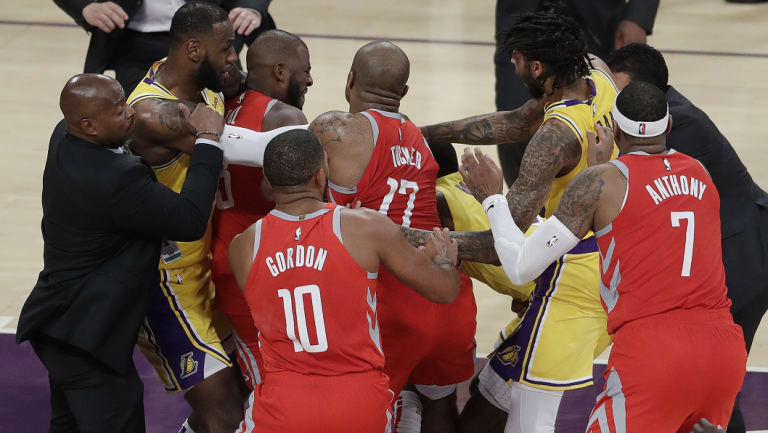 Houston Rockets' Chris Paul, second from left, is held back by Los Angeles Lakers' LeBron James, left, as Paul fights with Lakers' Rajon Rondo, centre obscured, during the second half of an NBA basketball game.
