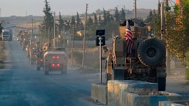 US military vehicles travel down a main road in northeast Syria.