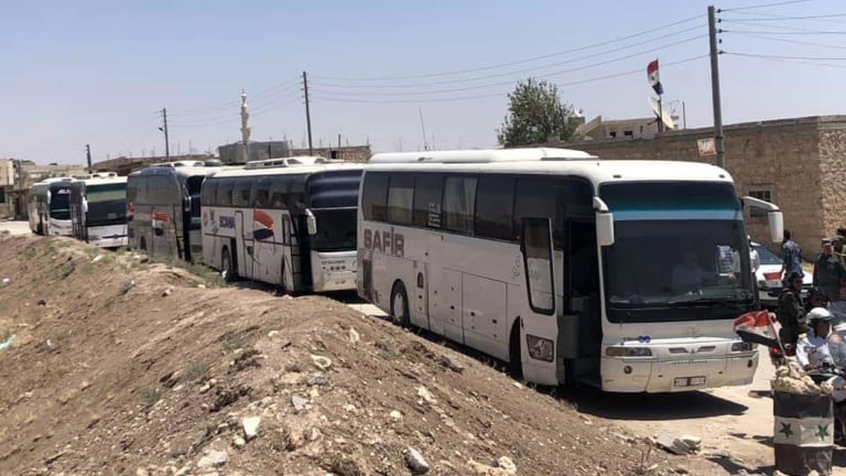 Buses arrive in Tel el-Eis, the crossing between Aleppo and Idlib provinces, as some 7000 people were evacuated from villages run by rebels, in July.
