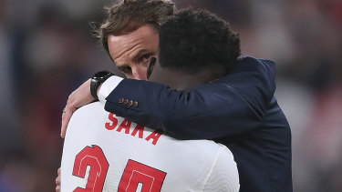 England’s manager Gareth Southgate, right, hugs England’s Bukayo Saka after the penalty shootout of the Euro 2020 soccer final match between England and Italy at Wembley stadium in London, Sunday, July 11, 2021.