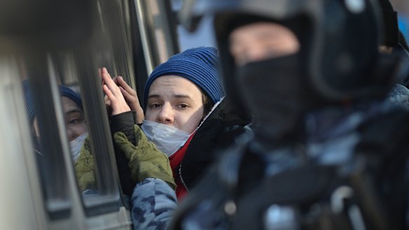 Police officers detain a young man during the hearing.