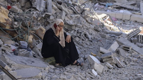 A Palestinian woman sits in the rubble of her home in the wake of an Israeli air and ground offensive in Jebaliya, northern Gaza Strip. 