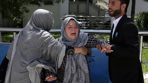 A woman shouts and cries at a hospital after she lost her son in the suicide attack on a voter registration centre.