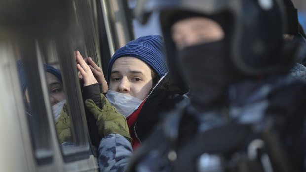 Police officers detain a young man during the hearing.