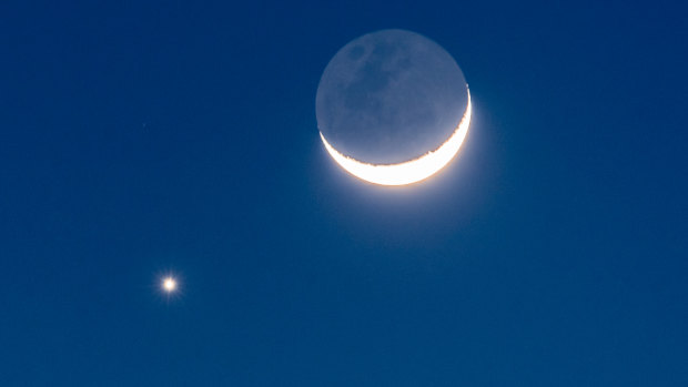 Venus and the crescent Moon in conjunction, with the glow of earthshine visible on the moon. 