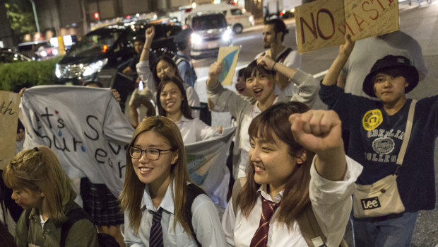 Participants hold signs and shout slogans during Global Climate Strike in Tokyo on Friday.