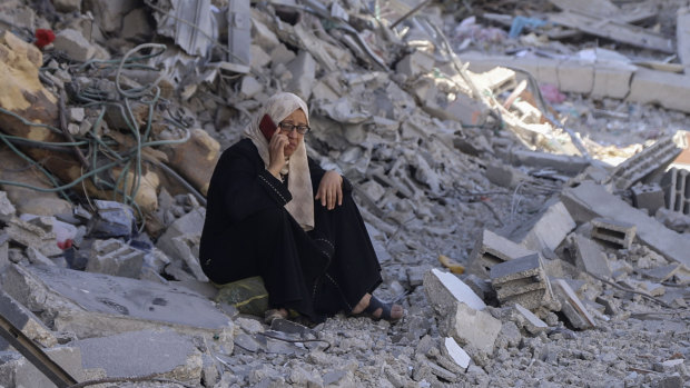 A Palestinian woman sits in the rubble of her home in the wake of an Israeli air and ground offensive in Jebaliya, northern Gaza Strip. 