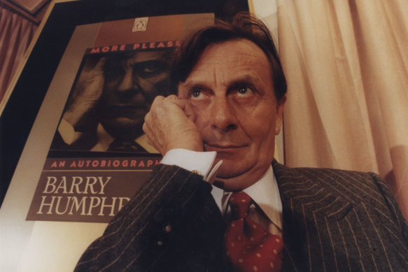 Barry Humphries with the cover of his autobiography behind him.