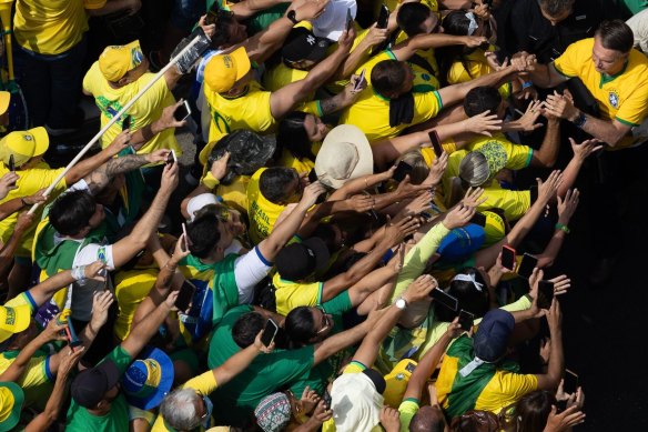 Former president Jair Bolsonaro (top right) greets supporters on arrival at the rally.