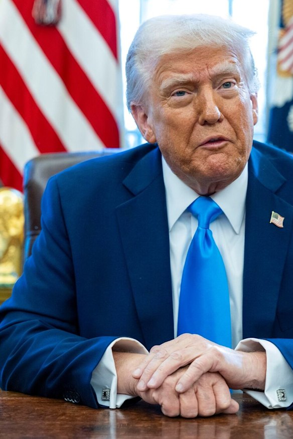 Trump signs an executive order in the Oval Office.