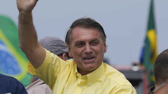 Brazilian President Jair Bolsonaro waves to supporters upon arrival to a motorcycle rally as he campaigns for a second term in Pocos de Caldas, Brazil on Friday, September 30.
