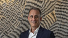 Wesfarmers CEO Rob Scott in his office in Perth. He stands in front of Wanapati Yunupinu art piece titled “Gurtha”.