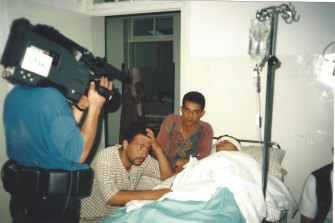 Filming a youth injured in clashes with Israeli soldiers in the occupied territories in 1996.
