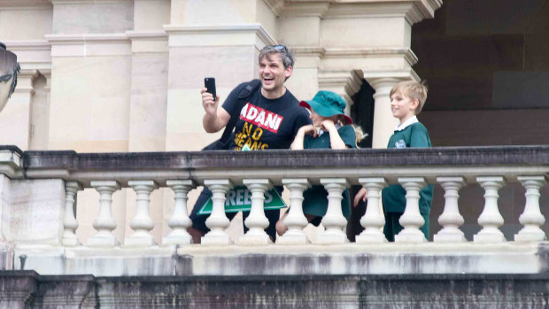 Queensland Greens MP Michael Berkman on the balcony in Parliament while wearing an anti-Adani T-shirt.
