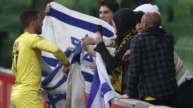 Tomer Hemed of the Phoenix wraps himself in the flag of Israel to celebrate a goal from a penalty during the A-League match between Melbourne City and the Wellington Phoenix.