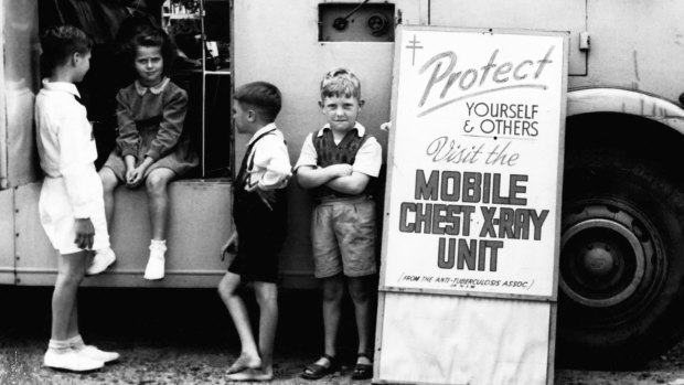 Children wait outside a mobile unit while their parents are being X-rayed inside.