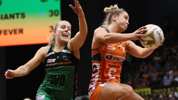 Human shield: Jamie-Lee Price of the Giants contests for the ball against Jessica Anstiss of the Fever.