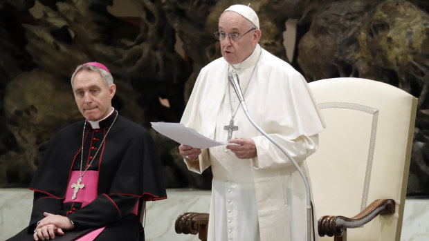 Pope Francis, flanked by Monsignor Georg Gaenswein, delivers his speech during an audience with Vatican employees, in the Pope Paul VI hall, at the Vatican.