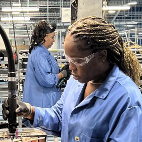 A production line worker assembles parts at Tritium’s new production plant