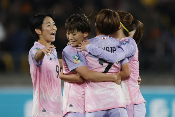 Hinata Miyazawa celebrates with teammates after scoring Japan’s third goal.