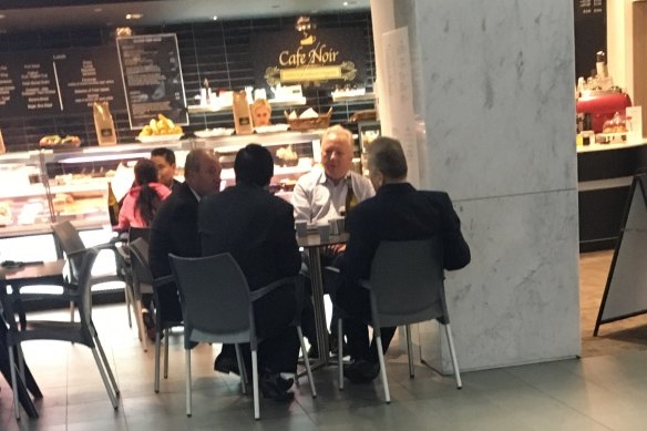 Daryl Maguire (left of image facing), unknown male 1 referred to as Ron (white shirt), Michael Hawatt (right, back to camera), Charbel Demian (left, back to camera). All males seated at the Cafe Noir 233 Castlereagh Street, Sydney. 