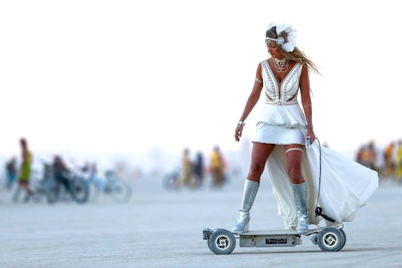 A woman rides an electric skateboard at Burning Man 2016.