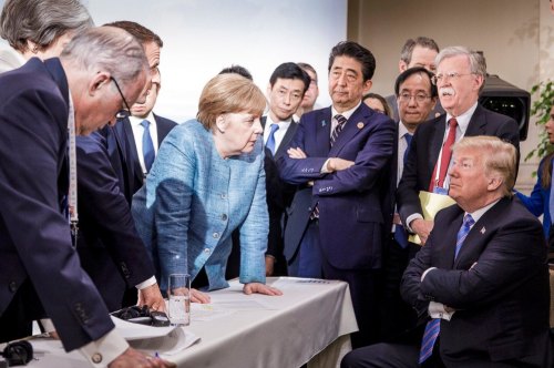 German Chancellor Angela Merkel, centre, speaks with U.S. President Donald Trump, seated at right, during the G7 Leaders Summit in La Malbaie, Quebec, Canada.