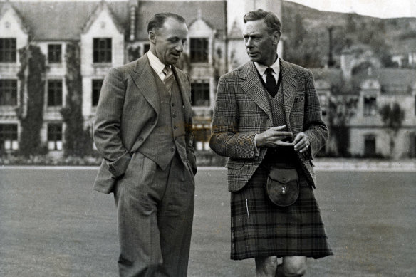 King George VI (right) walking with Sir Donald Bradman.