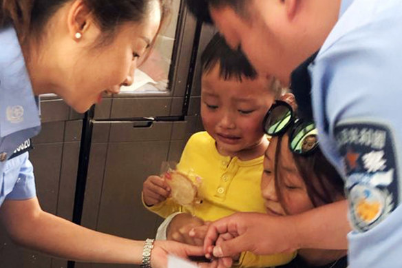Police officers from Shigu, China, collect DNA samples from a schoolboy in September.