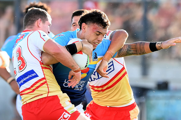 Iszac Fa’asuamaleaui of the Titans takes on the Dolphins defence during Sunday’s pre-season match.