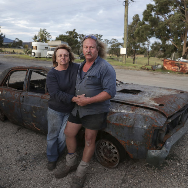 Gail and Brad Rayer with their burnt out 1971 Ford Falcon XY GTHO after bushfires destroyed large parts of their property and auto mechanic business near Cobargo, NSW.