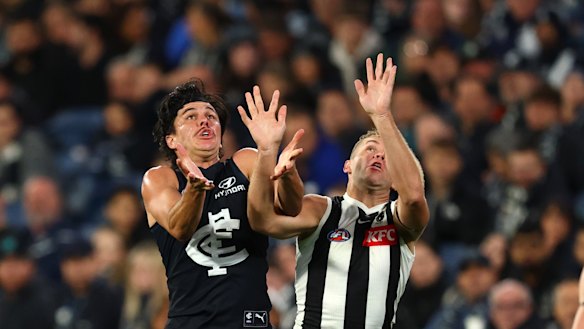 Elijah Hollands aborda Dan Houston, do Collingwood, pela bola.