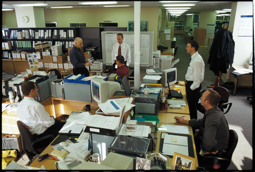 In the early 2000s, crew boss Jeff Maher (white shirt, middle) and squad boss Brian Rix (dark shirt) discuss an ongoing job.