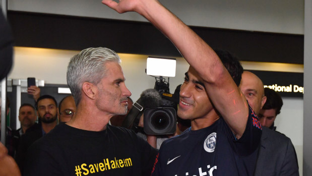 A jubilant Hakeem al-Araibi walks out of Melbourne Airport alongside former Socceroos captain Craig Foster.