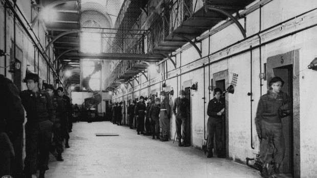 An individual guard stands before each cell in the main section of the Nuremberg jail where Nazi war criminals are lodged. The cells of Hermann Goering and Rudolf Hess are at the far right. 