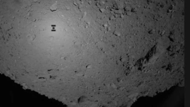 The shadow (centre left) of Japanese unmanned spacecraft Hayabusa 2 can be seen over the asteroid Ryugu.