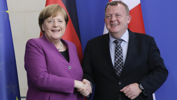 German Chancellor Angela Merkel, left, and the Prime Minister of Denmark Lars Loekke Rasmussen, right, shake hands after a meeting at the chancellery in Berlin.