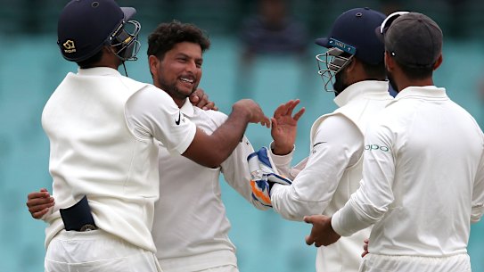 India's Kuldeep Yadav, second left, celebrates with teammates after taking the wicket of Australia's Nathan Lyon on day 4 of their cricket test match in Sydney.