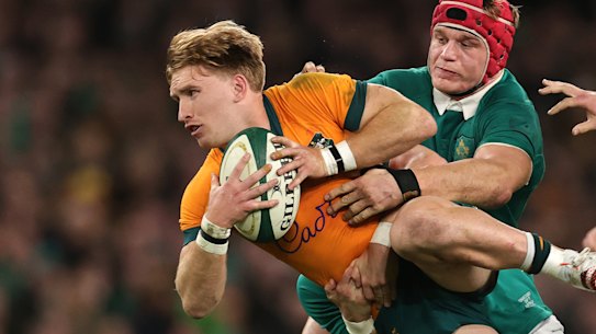 Tate McDermott of Australia is tackled by Craig Casey and Josh van der Flier.