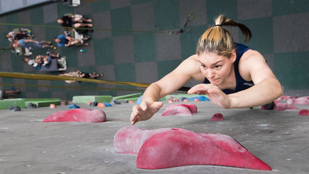 Oceana Mackenzie jumps and grasps for a hold in sport climbing practice for the Tokyo Olympics. 