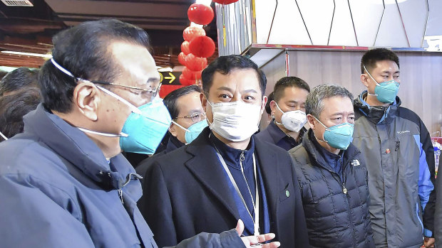Chinese Premier Li Keqiang (left) speaks with people at a supermarket in Wuhan,  Hubei province.