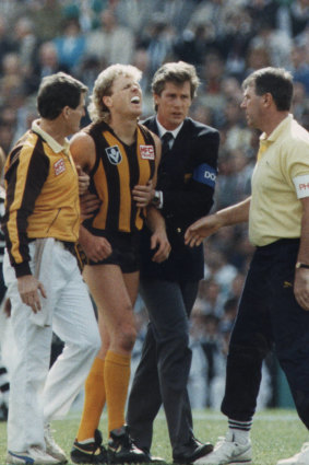 Dermott Brereton receives attention from medical staff after being flattened by Geelong's Mark Yeates in the opening moments of the 1989 Grand Final.