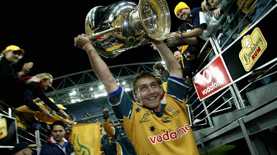 Mat Rogers holds the Bledisloe Cup aloft in 2002.