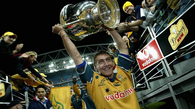 Mat Rogers holds the Bledisloe Cup aloft in 2002.