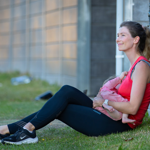Grace Preuss takes a minute to breastfeed her daughter at footy training.