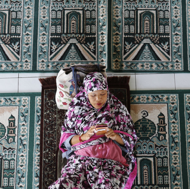 A woman rests at a mosque on the first day of Ramadan in Bali.