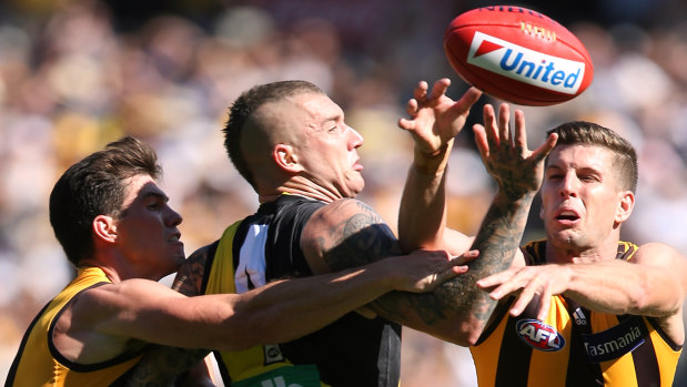 Up for grabs: Richmond's Dustin Martin attempts to mark despite the attentions of Hawthorn's Jaeger O'Meara and Luke Breust.
