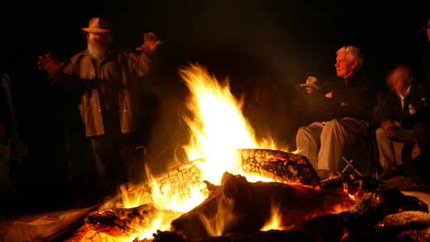 The Governor General Michael Jeffery sits around the campfire at Iga Warta Aboriginal Cultural Tourism Centre as Cliff Coulthard tells stories from the Adnyamathanha.